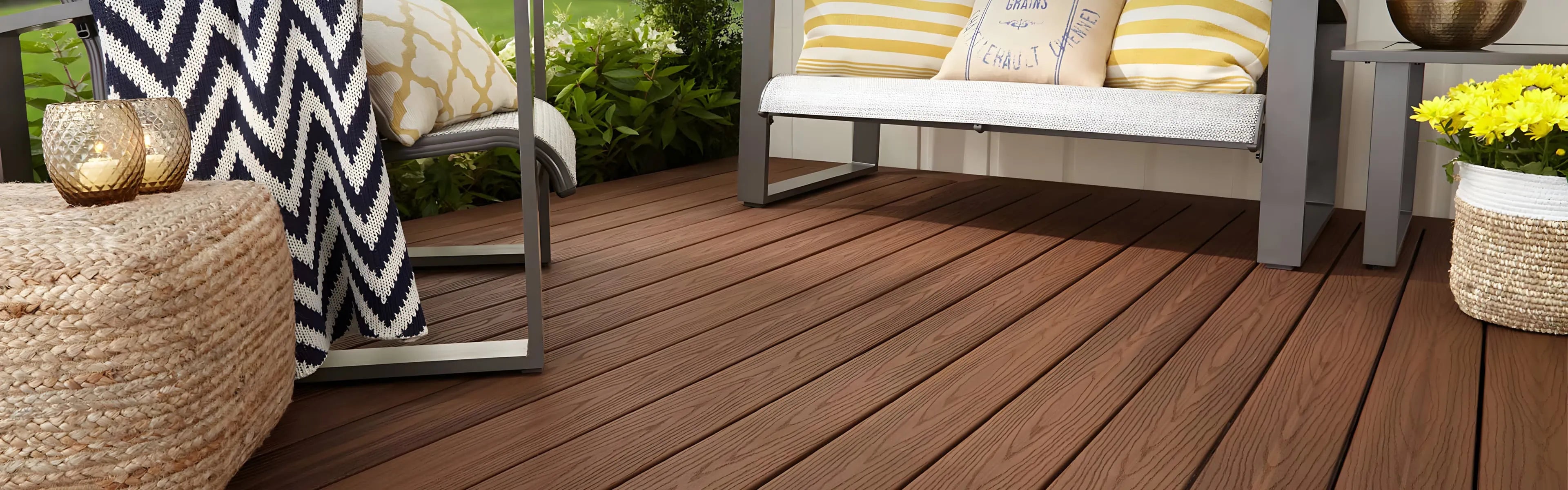 Spacious deck with cushioned chairs around a rectangular fire pit, overlooking trees and neighboring houses.