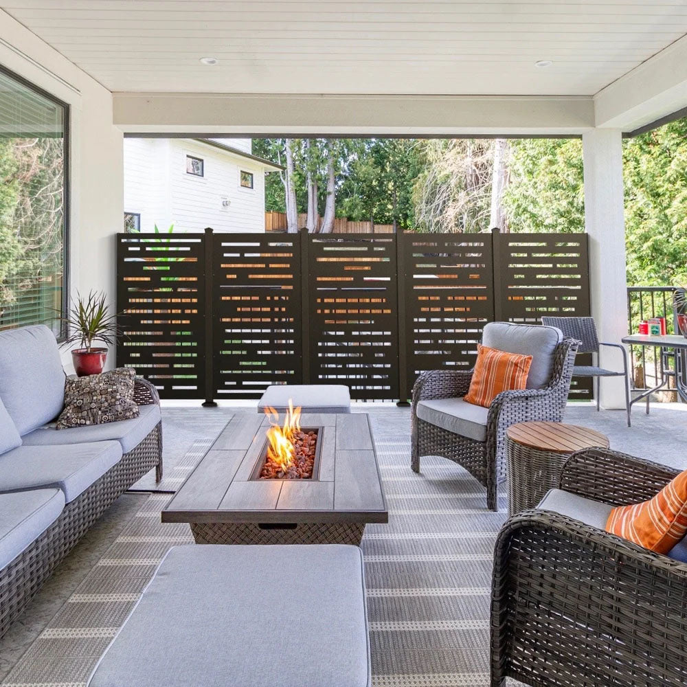 Modern patio with wicker furniture, gas fire pit table, and an aluminum privacy screen on a covered deck.