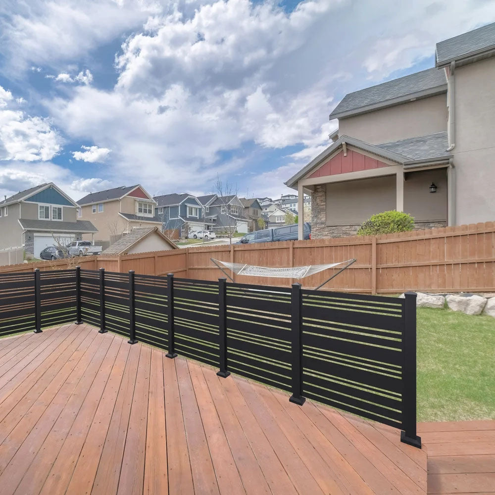 Wooden deck with black metal railing and a Sunbelly Privacy Screen overlooks backyard hammock and neighboring houses.